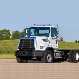 Freightliner 108SD truck displayed in pristine condition, emphasizing its powerful front grille, glossy white paint, and versatile chassis ready for customization.