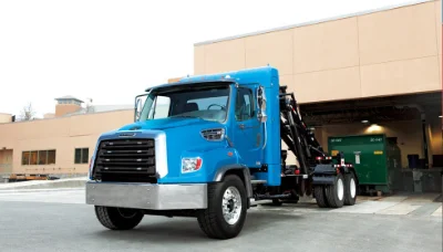 Freightliner 108sd Natural Gas blue truck with hydraulic lift parked outside a warehouse