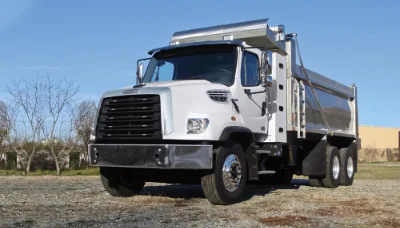 108sd Natural Gas white dump truck parked on gravel with clear blue sky background