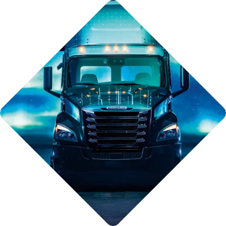 Front view of Freightliner eCascadia truck illuminated against a moody night background framed in a diamond shape