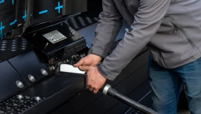 Close-up of hand plugging in charging cable to Freightliner eCascadia electric truck