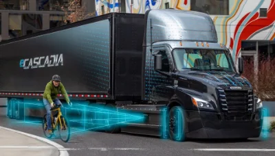 Freightliner eCascadia truck in city with cyclist beside and blue holographic road outline