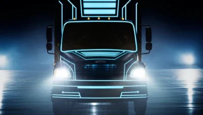 Front view of Freightliner eM2 electric truck with headlights on in a dark atmospheric setting