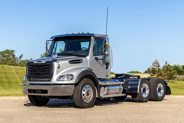 Freightliner M2 112 Plus Series cab view with chrome detailing parked on a clear day
