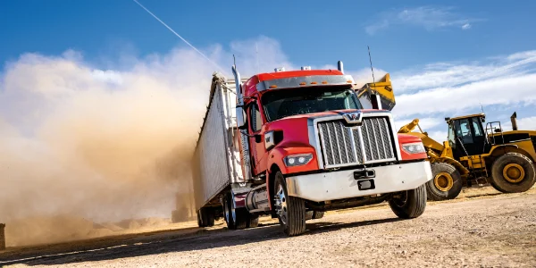 Red Western Star 49x truck speeding with dust cloud near yellow bulldozer in construction site, Ottawa Ontario dealership