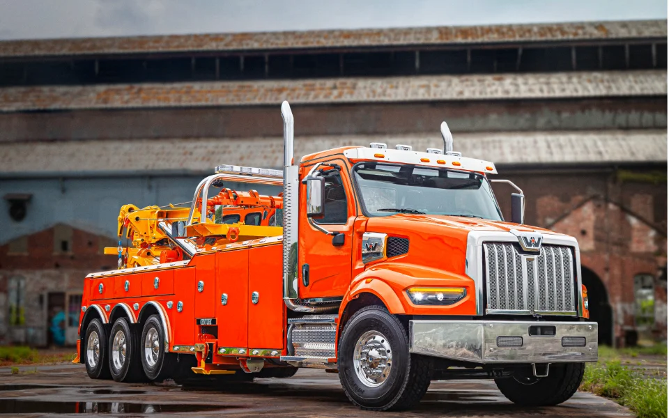 Orange Western Star 49x tow truck with equipment parked in an industrial setting, Ottawa Ontario dealership