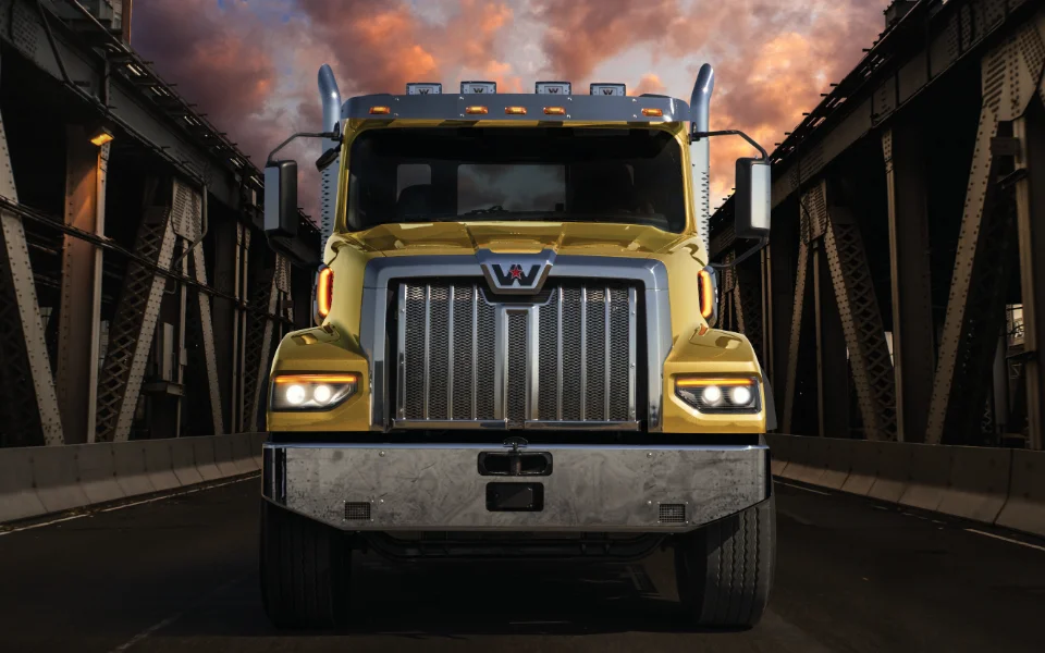 Golden Western Star 49x truck on a steel bridge with dramatic sunset sky, Ottawa Ontario dealership