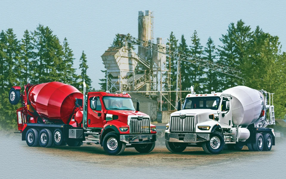 Red and white Western Star 49x concrete mixer trucks parked near a forestry area with industrial backdrop, Ottawa Ontario dealership